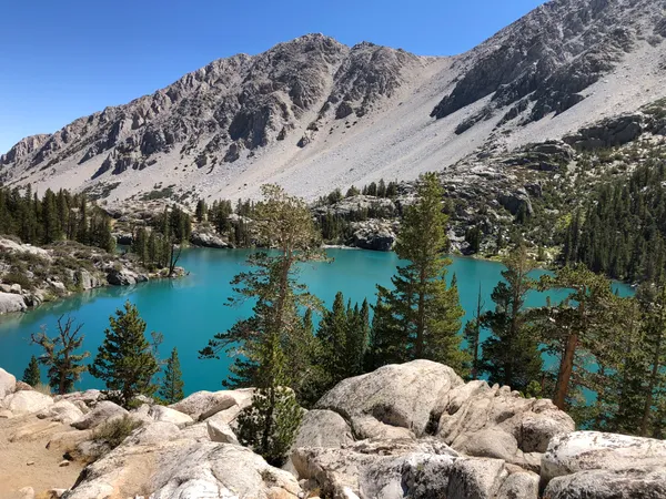 Turquoise alpine lake with clear mountain water and granite peaks in the Eastern Sierra