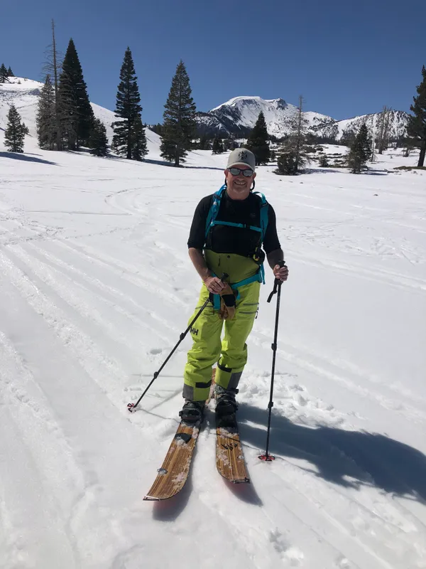 Michael smiling on skis on the slopes of Mammoth Mountain on a sunny winter day