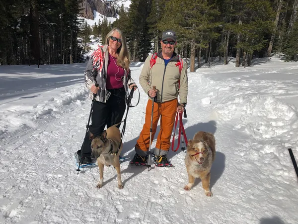 Michael and partner snowshoeing in winter snow with their two dogs
