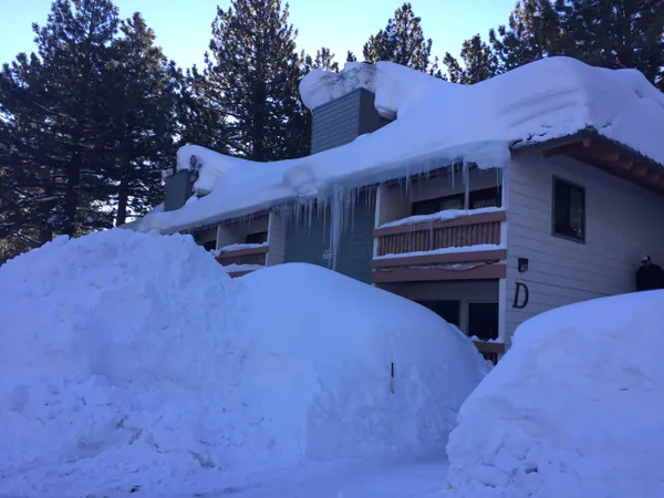 Mountain Shadows Building D buried up to the second-floor roof in a massive Sierra winter snowbank
